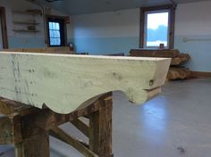 a large wooden bench sitting in a room next to some windows and wood planks