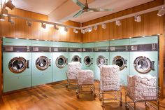 several washers and dryers in a room with wooden floors