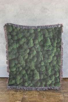 a blanket with green plants on it