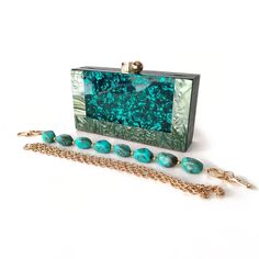 Stylish and original. Celebrate your next resort holiday in style with the Tropical Oasis Teal Acrylic Clutch Bag! This stunning design exudes sophistication and glamour, transforming any outfit into a dreamy oasis of chic fashion. Why We Love It...The striking turquoise hue of the acrylic exterior evokes the tranquility of a tropical oasis, making this teal clutch a unique and eye-catching accessory for your resort escapades. The dreamy turquoise reflection with the glossy finish and the gold h Elegant Green Summer Evening Bag, Elegant Green Evening Bag For Summer, Elegant Green Evening Bag, Elegant Green Evening Bag With Chain Strap, Elegant Green Clutch With Detachable Strap, Acrylic Bag, Beaded Clutch Bag, Acrylic Clutch, Tropical Oasis