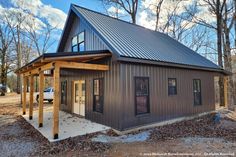 a small house in the woods with a metal roof