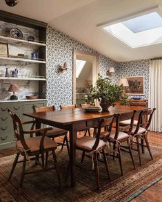 a dining room table and chairs with a skylight in the middle of it,