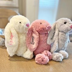 three stuffed animals sitting next to each other on a table