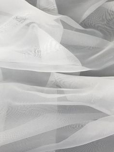 white sheer fabric blowing in the wind with no visible lines or shapes on it's surface