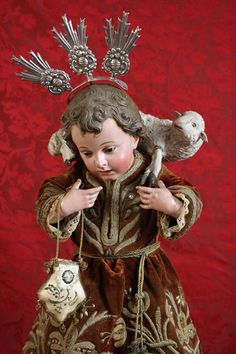 an antique figurine holding a bird on its shoulder