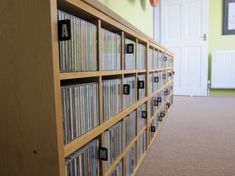 a large wooden shelf filled with cd's in a room next to a door