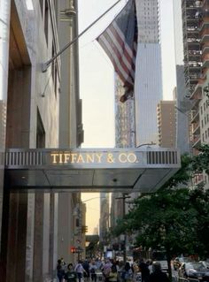 the entrance to tiffany & co in new york city, ny with people walking under it