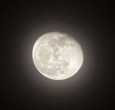 the full moon is seen in the dark sky with only one light on it's side