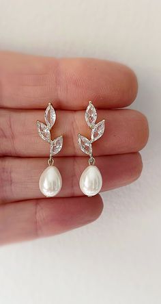 Our pearl drop bridal earrings are simply stunning!  A simple classic earring. Little bit of bling, classic pearl, small drop... perfect combo!  These dainty pearl drop earrings catch the light, packing serious sparkle for their size. Combining marquise crystals stones in a modern leaf design they're finished with glowing Swarovski pearls. With just the right amount of sparkle, this dainty pair is perfect for brides, mother of the bride and bridesmaids alike. Available in silver or gold to suit all skin tones.  -Drop Pearls are light ivory- These Crystal and pearl wedding earrings will add a flawless finish to every bridal look. Gorgeous Coordinating crystal Leaf Hair comb  and Necklace set also available. SHOP MORE STYLES  https://www.etsy.com/ie/shop/BridalStar?ref=related&listing_id=768 Pearl Drop Earrings Wedding, Brides Mother, Pearl Drop Earrings Bridal, Pearl Bridal Earrings, Small Drop Earrings, Earrings And Necklace Set, Crystal Bridal Earrings, Pearl Earrings Wedding, Bridal Jewelry Set