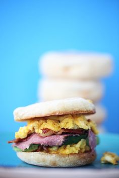 an egg, ham and cheese sandwich is on a plate with crackers in the background