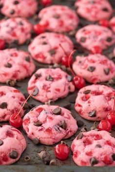 chocolate chip cookies with cherries and chocolate chips in them on a baking sheet, ready to be eaten