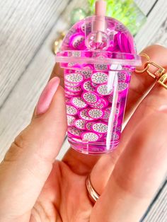 a person holding a pink and white cup with lots of hearts on the inside, in front of a wooden table