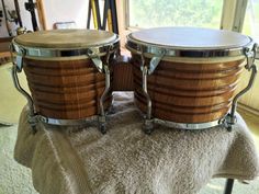 two wooden drums sitting on top of a towel