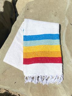 a beach towel laying on top of a rock