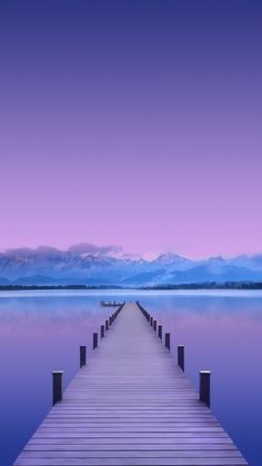 a dock in the water with mountains in the background