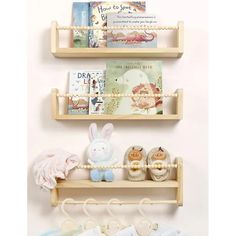 three wooden shelves with books and stuffed animals on them, hanging from the wall next to each other