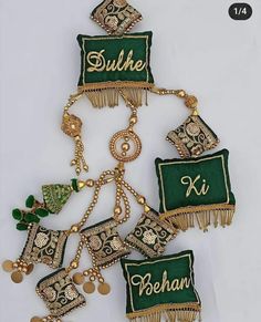 some green and gold brooches are hanging on a white surface with other items