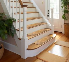 a set of stairs with wooden treads in front of a potted plant on the floor