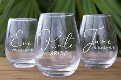 three wine glasses sitting on top of a table next to each other with names painted on them