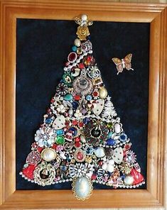 a wooden frame with a christmas tree made out of buttons and other things in it