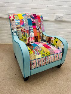 a colorful patchwork chair sitting in front of a white brick wall and carpeted floor