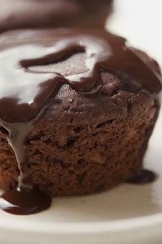 a close up of a muffin on a plate with chocolate sauce drizzled over it