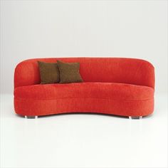 an orange couch with two pillows on it's back and one pillow on the side