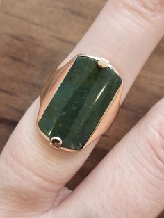 This is a 10k yellow gold ring set with a 20mm by 11mm green jade stone. It is a size 5.25 and weighs 5.2 grams or 3.3 dwt. Modern Green Signet Ring With Polished Finish, Green 14k Stamped Signet Ring, Green 14k Gold Signet Ring Fine Jewelry, 14k Gold Green Ring With Polished Finish, 14k Gold Green Rectangular Ring, Green Emerald Cut Signet Ring With Polished Finish, Green Emerald-cut Signet Ring With Polished Finish, Rectangular Green 14k Gold Ring, Green Rectangular 14k Gold Ring