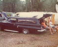 two people sitting in the back of an old pickup truck