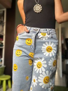 a woman wearing jeans with smiley faces on them