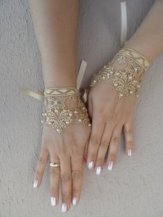 two hands with white and gold bracelets on them