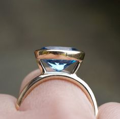 A delicious swiss blue topaz ring made in 100% recycled 9ct yellow gold. The setting not only allows you to see the full glory of the stone but also allows the ring to be stacked up with other bands to create your own custom set. This stone is 11 x9 mm, 3ct. The ring can be made with other gemstones and in different shapes and sizes , just ask for a quote.It is a made to order ring, in the size that you need. Orders take 3-4 weeks. For other stacking rings , got to:www.karenjohnsondesign.etsy.co Modern 14k Gold Topaz Ring With Bezel Setting, Modern 14k Gold Bezel Set Topaz Ring, Gold Solitaire Blue Topaz Ring, Modern Topaz Ring In 14k Gold With Prong Setting, Modern 14k Gold Topaz Ring With Prong Setting, Yellow Gold Solitaire Blue Topaz Birthstone Ring, Blue Topaz Ring With Bezel Setting For Promise, Yellow Gold Topaz Solitaire Ring, 14k Gold Topaz Ring With Bezel Setting For Promise