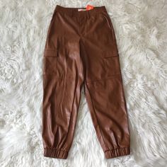 Camel Color Cargo Faux Leather Pants With Elastic At Bottom. Belt Loops With 2 Large Pockets On Side. A Must In Your Closet Great To Pair With Heels And A Bodysuit. Casual Faux Leather Cargo Pants With Pockets, Leather Cargo Pants For Fall, Trendy Brown Leather Pants With Pockets, Casual Faux Leather Cargo Pants, Brown Faux Leather Pants With Pockets, Casual Faux Leather Pants With Faux Pockets, Casual Leather Pants With Faux Pockets For Fall, Casual Leather Pants With Faux Pockets For Work, Spring Leather Pants With Pockets