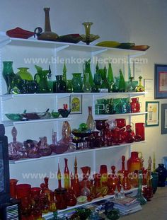 the shelves are filled with many different colored glassware