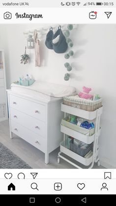 a baby crib in the corner of a room next to a dresser with baskets on it