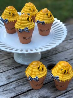 cupcakes decorated like honeybees with bow ties on a white cake plate