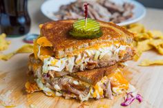 a sandwich cut in half sitting on top of a wooden cutting board next to chips