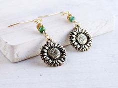 I created these delightful drop earrings in the colors of a golden autumn sunflower, with Picasso seed beads in natural and green, from which I have suspended double-sided antique gold plated sunflower charms made in the USA. The French hook ear wires are gold tone plated (nickel free) and include earring backs. These earrings measures 1 3/4 inches from the top of the earwire to the bottom of the sunflower. This is a great length as they are long enough to be seen but are still lightweight. The Bohemian Sunflower Design Flower Earrings As Gift, Bohemian Sunflower Earrings For Gift, Bohemian Sunflower Earrings As Gift, Bohemian Sunflower Design Earrings For Gift, Hypoallergenic Gold Bohemian Beaded Earrings, Bohemian Sunflower Drop Earrings, Gold Sunflower Dangle Jewelry, Gold Sunflower Adjustable Flower Earrings, Adjustable Gold Sunflower Earrings