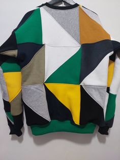 a multicolored sweater hanging on a white wall