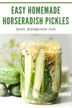 a jar filled with pickles sitting on top of a table next to cucumbers