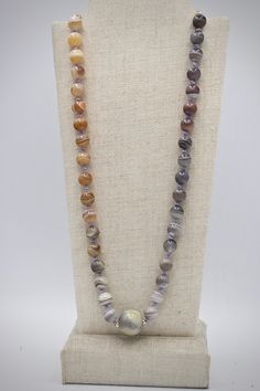 "This handmade organic necklace is made of round glossy 8mm agate beads. Agate comes in a variety of colors naturally and a range of grey purples to warm peach tones are showcased in this gradient piece. The stripes on these stones are a cool white and resemble planetary bodies. The overall golden tones of the agate beads are complimented with a gold-filled chain and spacer beads around the central 12mm round stone. The beads are knotted between the chain on lavender-colored silk. This piece arr Gray Bohemian Necklace With Round Beads, Bohemian Gray Round Bead Necklace, Single Strand Agate Round Necklace, Gray Gemstone Beads Necklaces For Gifts, Gray Gemstone Beads Necklace For Gift, Single Strand Round Agate Necklace, Handmade Spiritual Gray Necklaces, Adjustable Gray Necklace With Gemstone Beads, Adjustable Gray Gemstone Beads Necklace