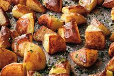 cooked potatoes with herbs and seasoning on a baking sheet, ready to be eaten