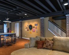 a living room filled with furniture next to a kitchen and dining room table in front of a bar