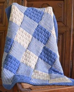 a blue and white blanket sitting on top of a wooden chair