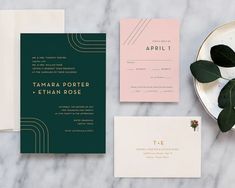 the wedding stationery is laid out on a marble table