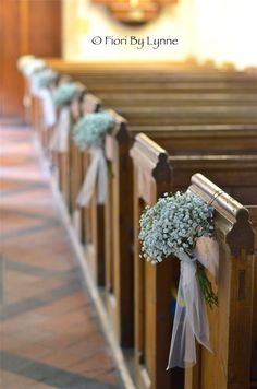 flowers are tied to pews at the end of a church