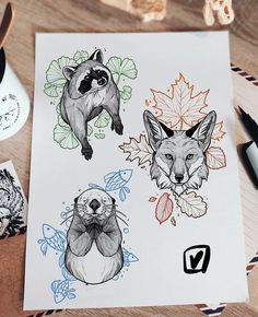 two drawings of foxes and leaves on a piece of paper next to some markers, pens and pencils