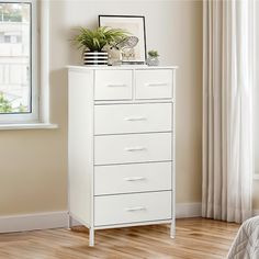 a white chest of drawers sitting next to a window