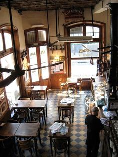 an overhead view of a restaurant with tables and chairs in front of large windows, looking down at the dining area