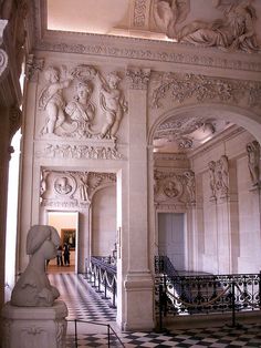 an ornate hallway with statues on the walls